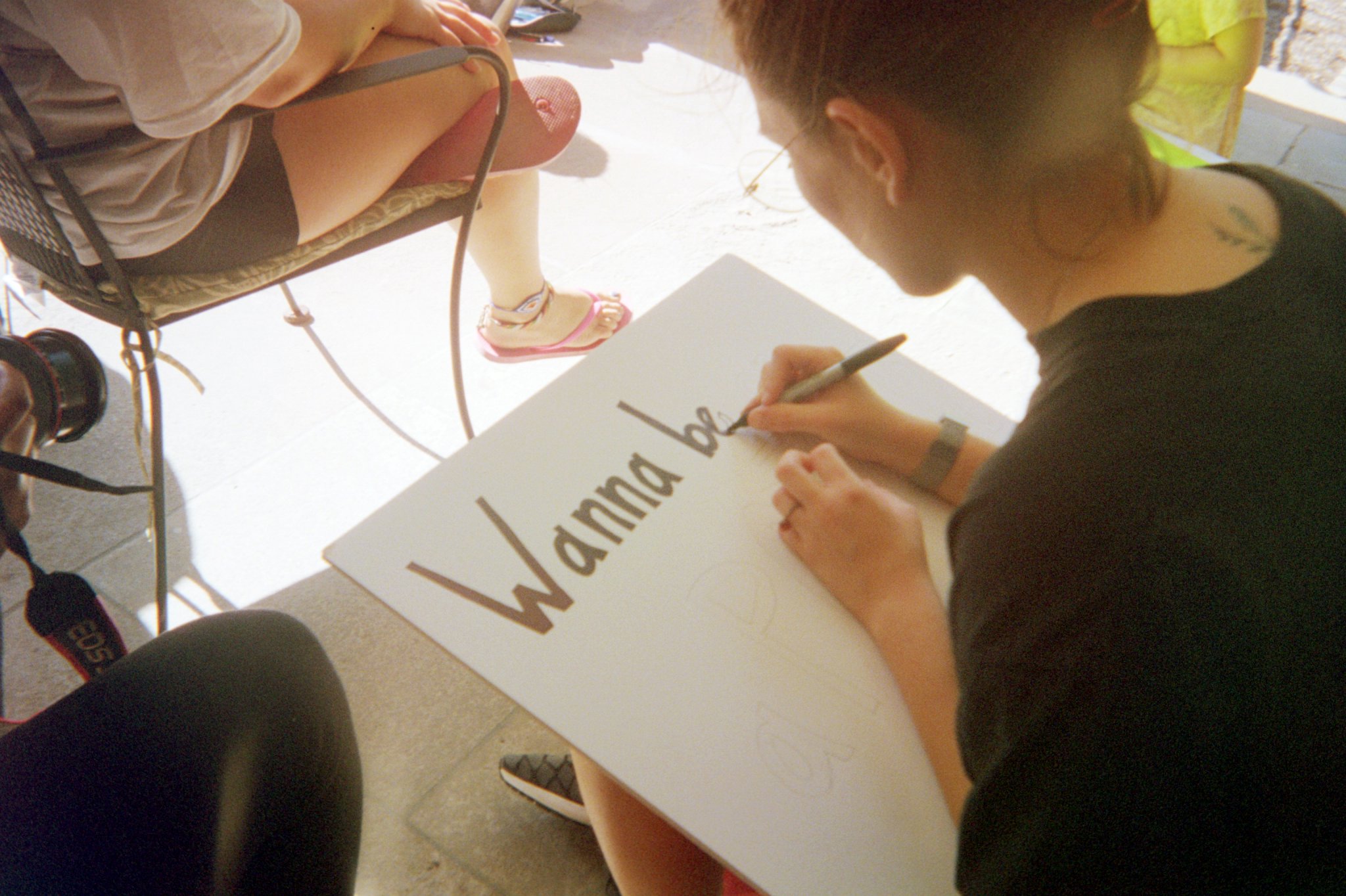 Althea working on a sign. She's filling in the "e" in "Wanna be in our podcast?"